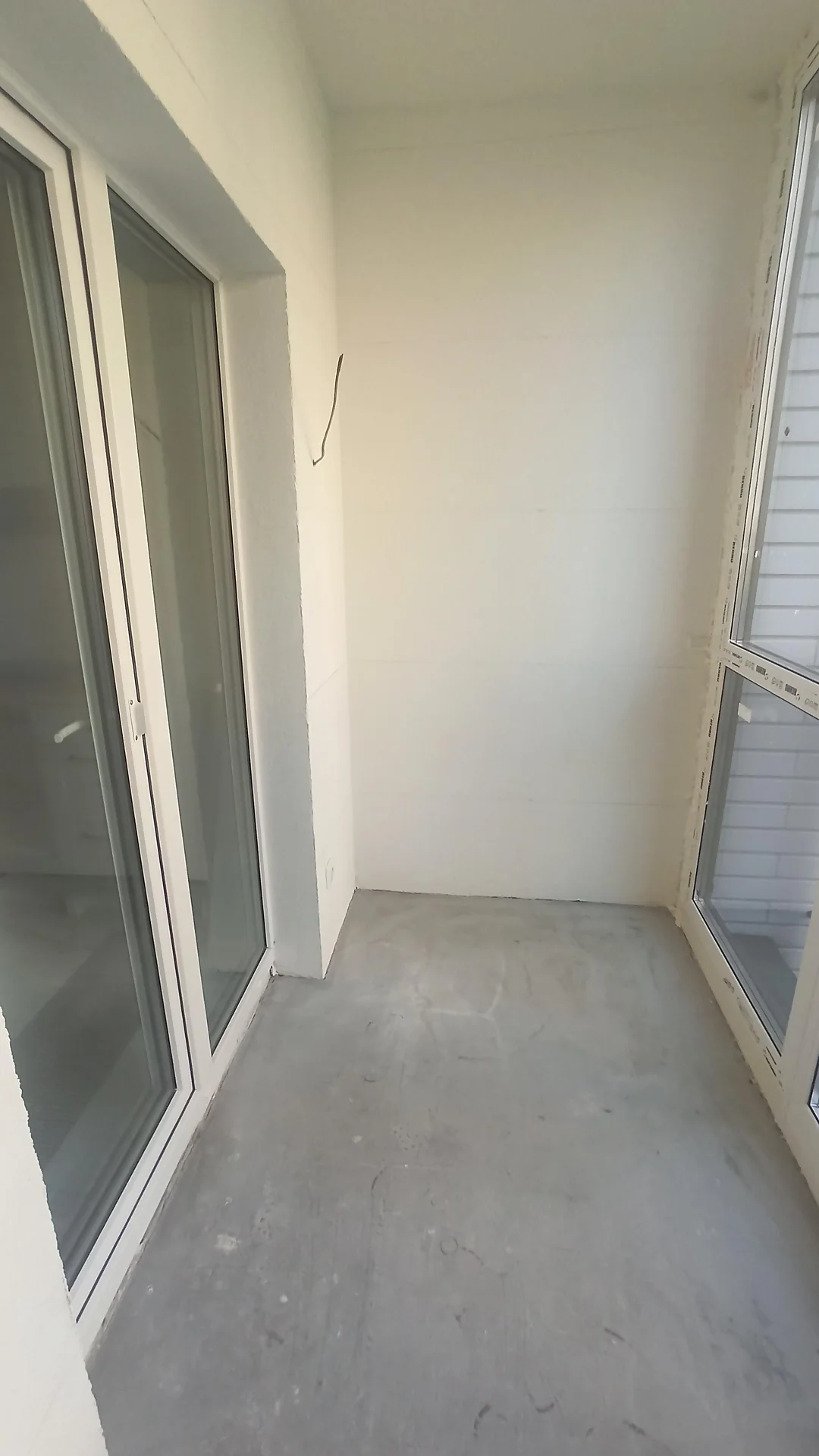 Белые оштукатуренные стены балкона до ремонта